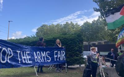 Protesters holding a banner that says Stop The Arms Fair