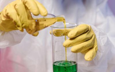 Photo of chemist handling liquids while wearing full PPE