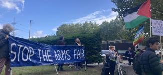 Protesters holding a banner that says Stop The Arms Fair